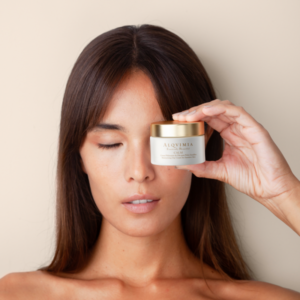 Mujer realizando un ritual de belleza con cosmética natural Alqvimia y aceite corporal.